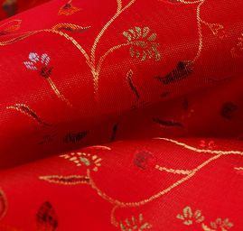 Látka brokát květy na červeném podkladě