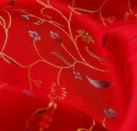 Látka brokát květy na červeném podkladě