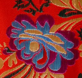 Brokát s folklórním motivem květů červený