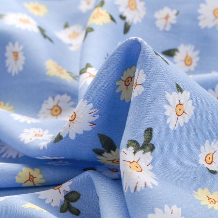Viskozová šatová látka květy žlutobílé na modré