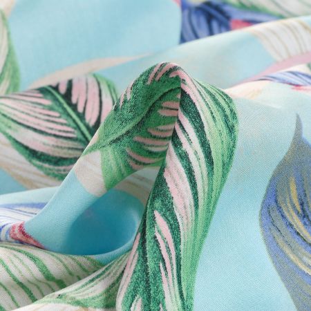 Viskozová šatová látka listy světle modrá