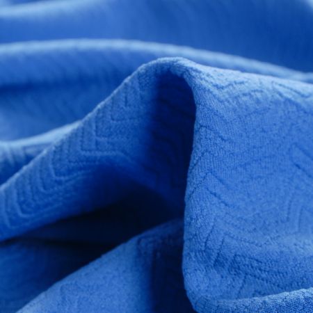 Pletenina s plastickým vzorem vlnek modrá